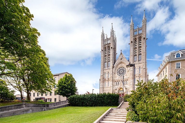 View of the basilica's prominent architecture standing on a hill, featuring its stone facade and twin towers.